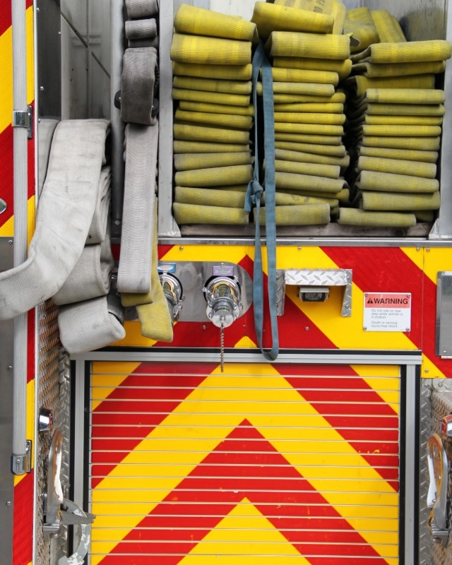 Rolled up firehoses, pictured from the back of a firetruck.